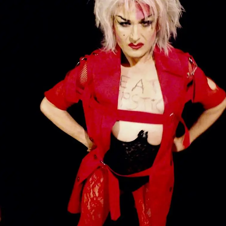 Anita posing in a ripped red dress